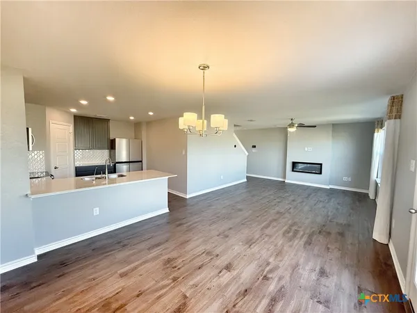 a large kitchen with a lot of cabinets and wooden floor