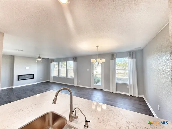 a view of an empty room and window and wooden floor