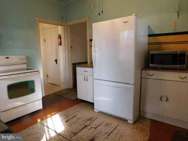 a white refrigerator freezer and a stove sitting inside of a kitchen