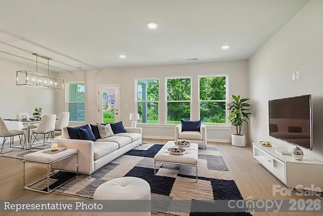 a living room with furniture a flat screen tv and a large window