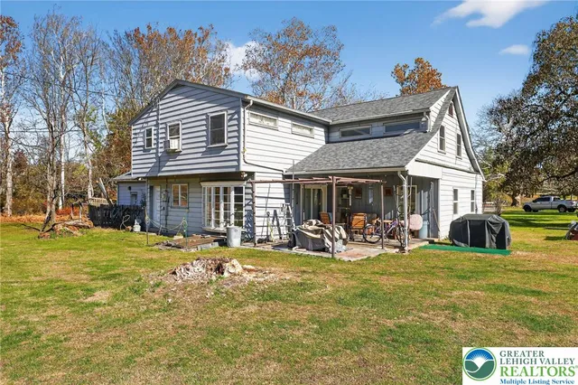 a view of a house with a yard patio and fire pit