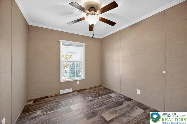 a view of an empty room and window and a ceiling fan