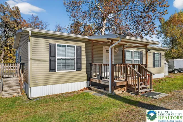 a view of a house with a yard chairs and iron fence