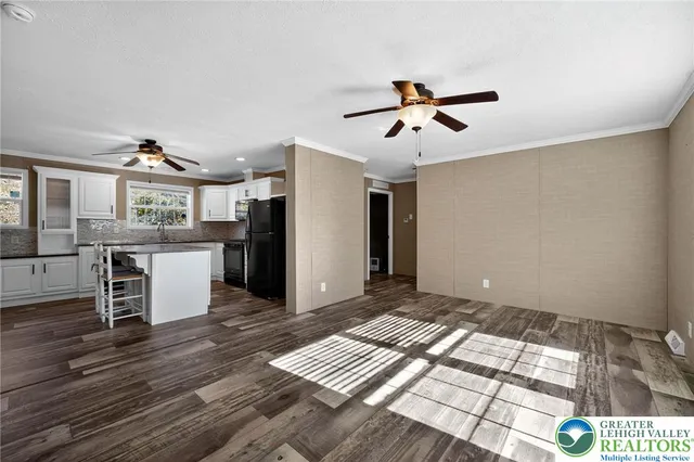 a view of a kitchen with wooden floor and a ceiling fan
