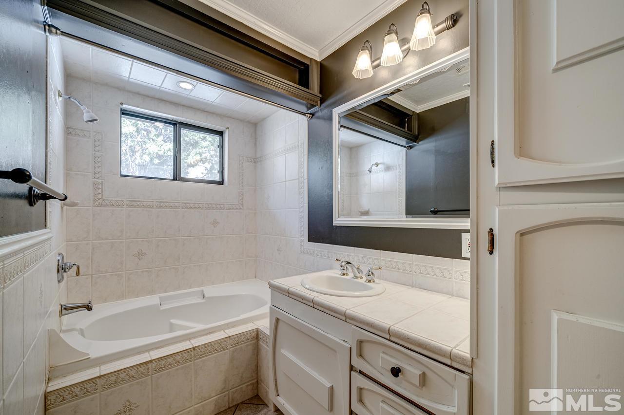 15920 Toll Road Reno, NV 89521 - Photo 21 of 24 a bathroom with a tub sink and mirror