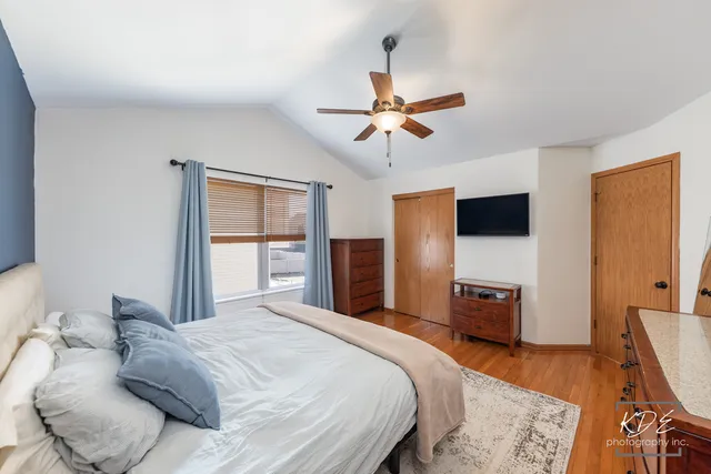 a bedroom with a bed and a flat tv screen on dresser