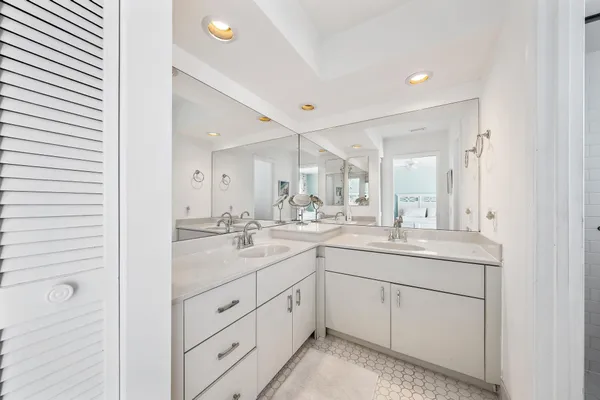 a bathroom with a double vanity sink and mirror with shower