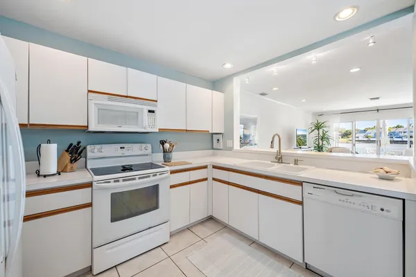 a kitchen with white cabinets and white appliances