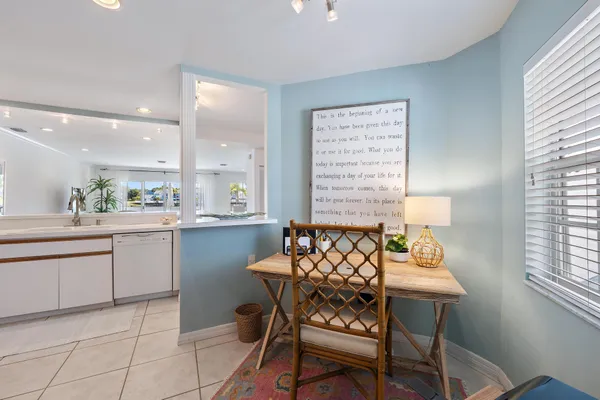 a dining room filled a chandelier and kitchen view