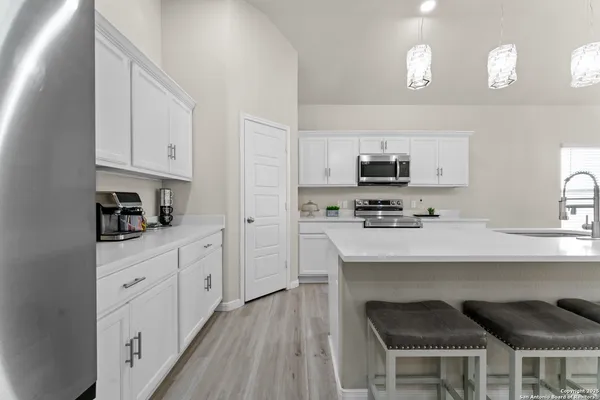 a kitchen with a sink a counter space appliances and cabinets