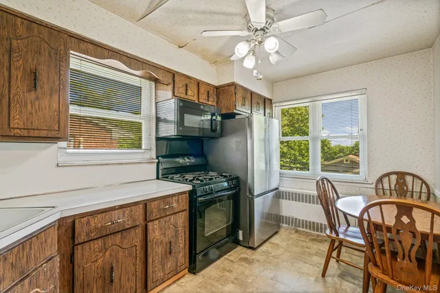 a kitchen that has a cabinets a stove a sink and a dining table
