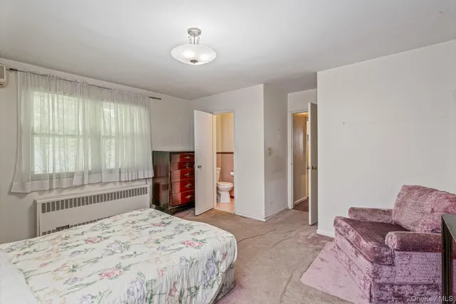 a bedroom with a bed and dresser with mirror