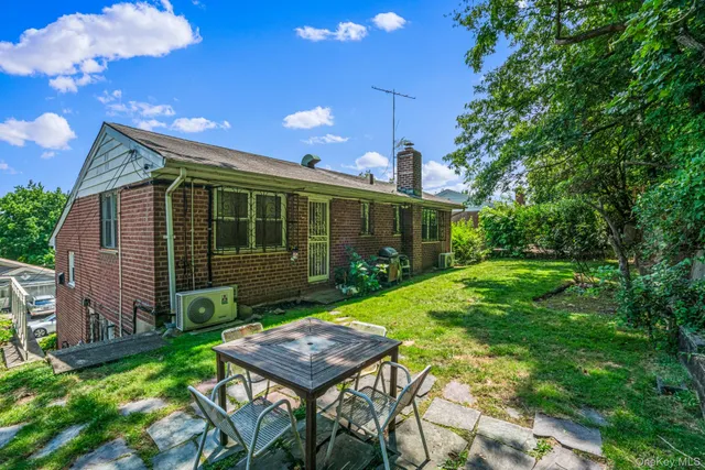 a backyard of a house with table and chairs