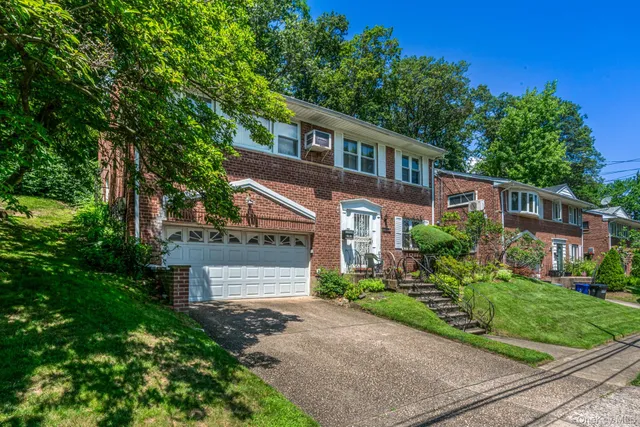 a front view of a house with a yard and potted plants
