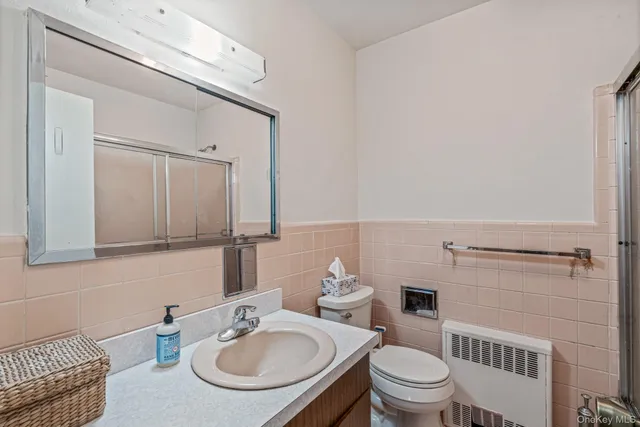 a bathroom with a sink a toilet and a mirror