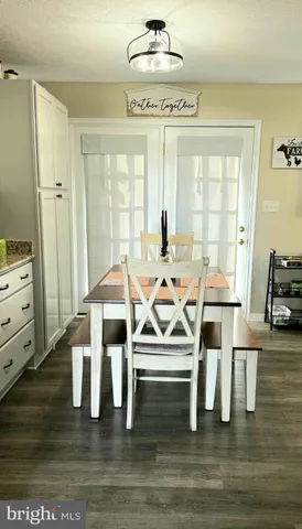 a dinning room with wooden floor table and chairs