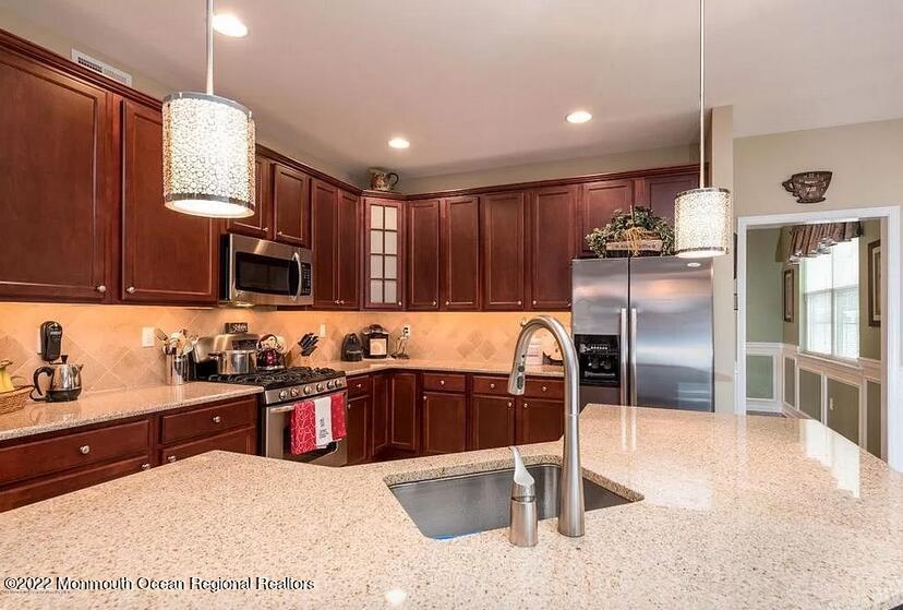 8 Firenze Road Jackson, NJ 08527 - Photo 10 of 23 a kitchen with stainless steel appliances granite countertop a sink wooden cabinets and a refrigerator