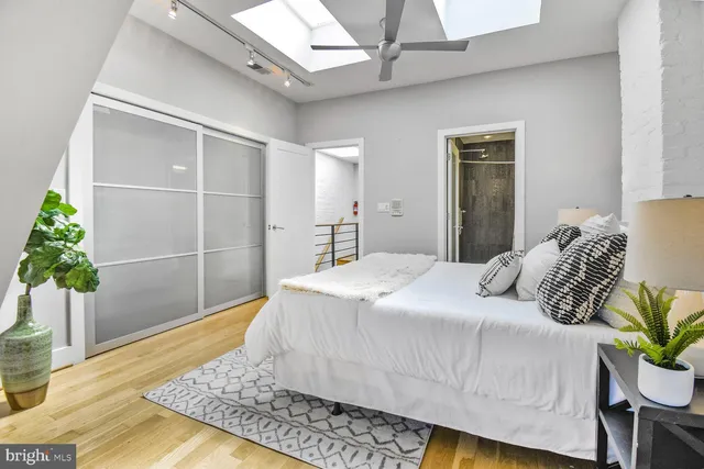 a bedroom with a large bed and a potted plant