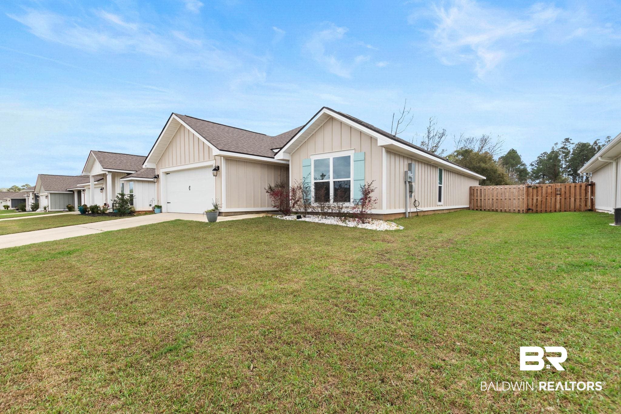 1203 Hayward Loop Foley, AL 36535 - Photo 2 of 41 View of front facade featuring a garage, driveway, board and batten siding, and roof with shingles