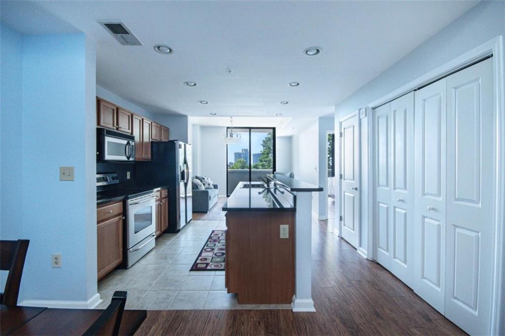 3040 Peachtree Road, Unit 507 Atlanta, GA 30305 - Photo 3 of 33 a living room with furniture a flat screen tv and a refrigerator