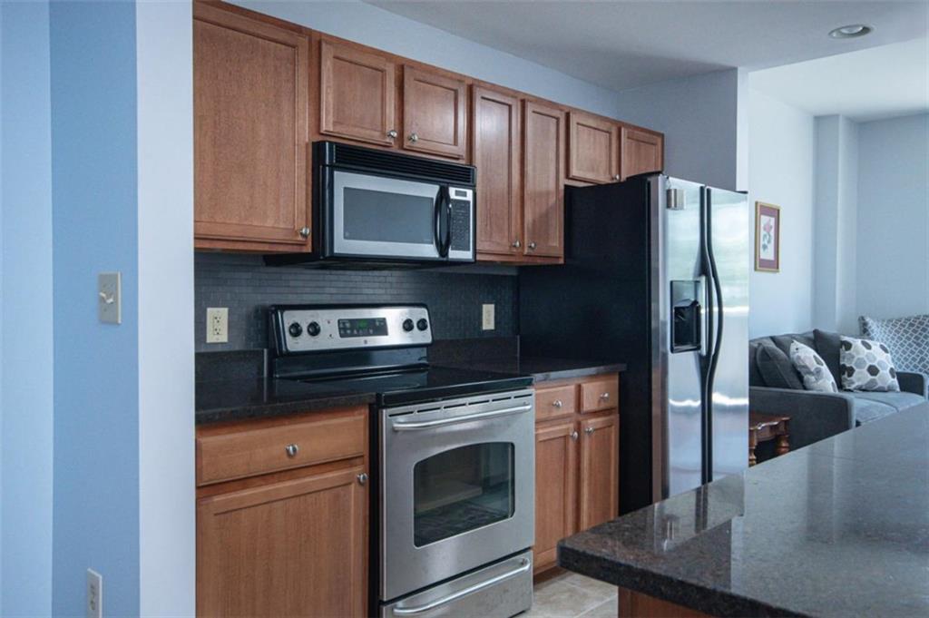 3040 Peachtree Road, Unit 507 Atlanta, GA 30305 - Photo 8 of 33 a kitchen with stainless steel appliances granite countertop a refrigerator stove and microwave