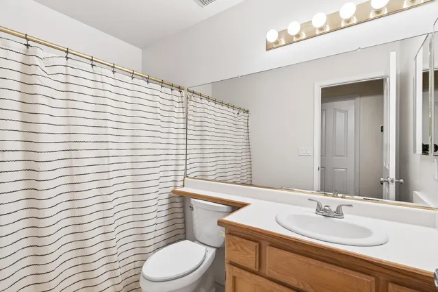 a bathroom with a sink a toilet and mirror
