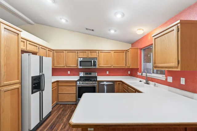 a kitchen with stainless steel appliances a refrigerator sink and stove