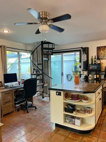 a room with stainless steel appliances kitchen island granite countertop furniture and a large window