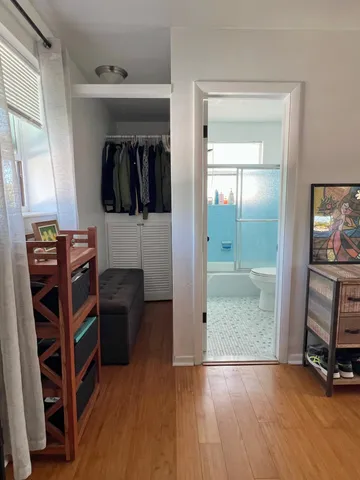 a view of a hallway with wooden floor and furniture