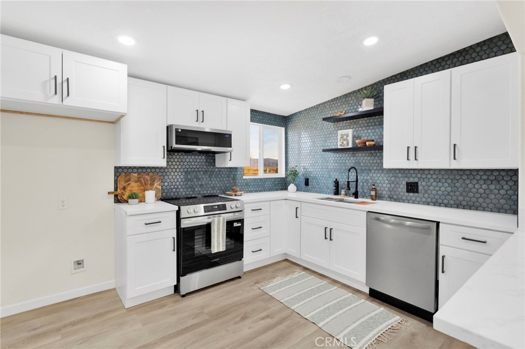 14344 Central Road Apple Valley, CA 92307 - Photo 12 of 61 a kitchen with granite countertop white cabinets and appliances