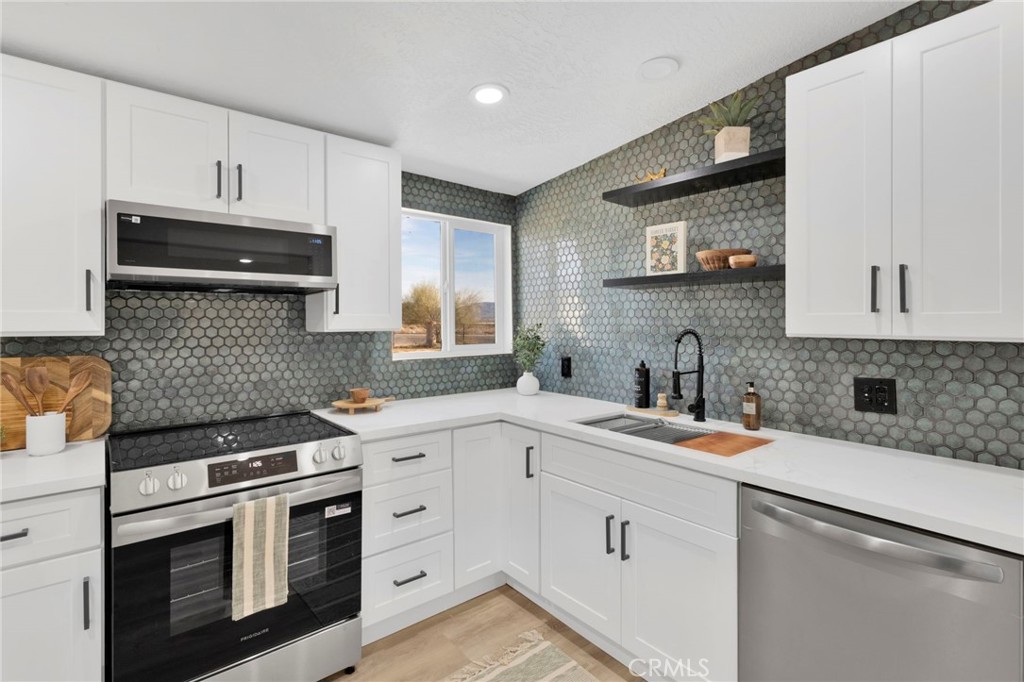14344 Central Road Apple Valley, CA 92307 - Photo 14 of 61 a kitchen with white cabinets appliances and a sink