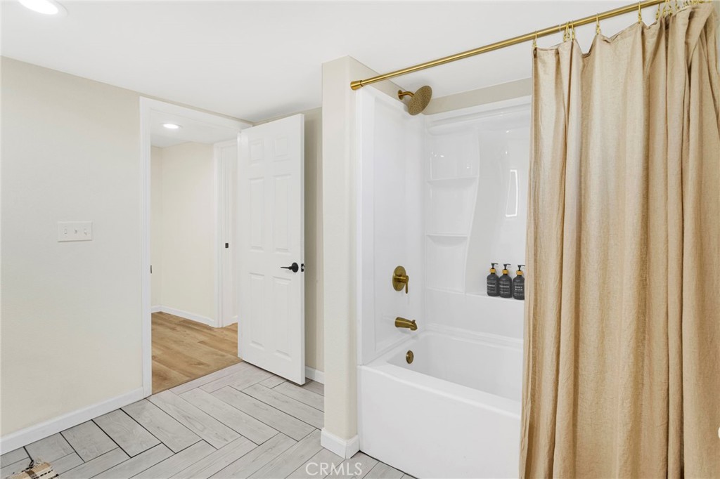 14344 Central Road Apple Valley, CA 92307 - Photo 23 of 61 a bathroom with a shower curtain and a bathtub