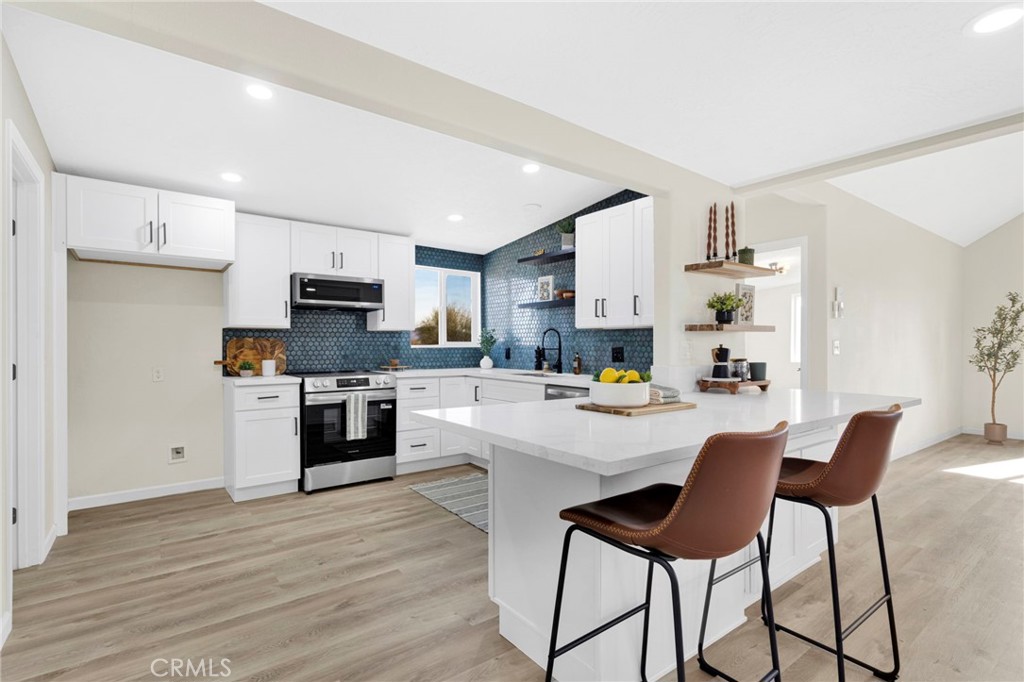 14344 Central Road Apple Valley, CA 92307 - Photo 10 of 61 a kitchen with white cabinets and stainless steel appliances