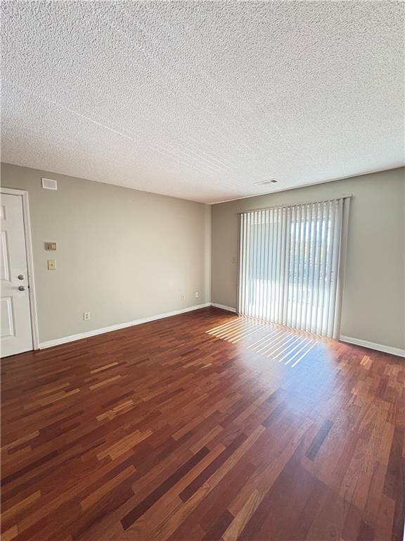 2657 Lenox Road Northeast, Unit 31 Atlanta, GA 30324 - Photo 4 of 18 a view of an empty room with wooden floor and a window