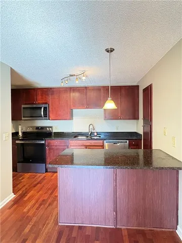 a kitchen with kitchen island granite countertop a stove and a sink
