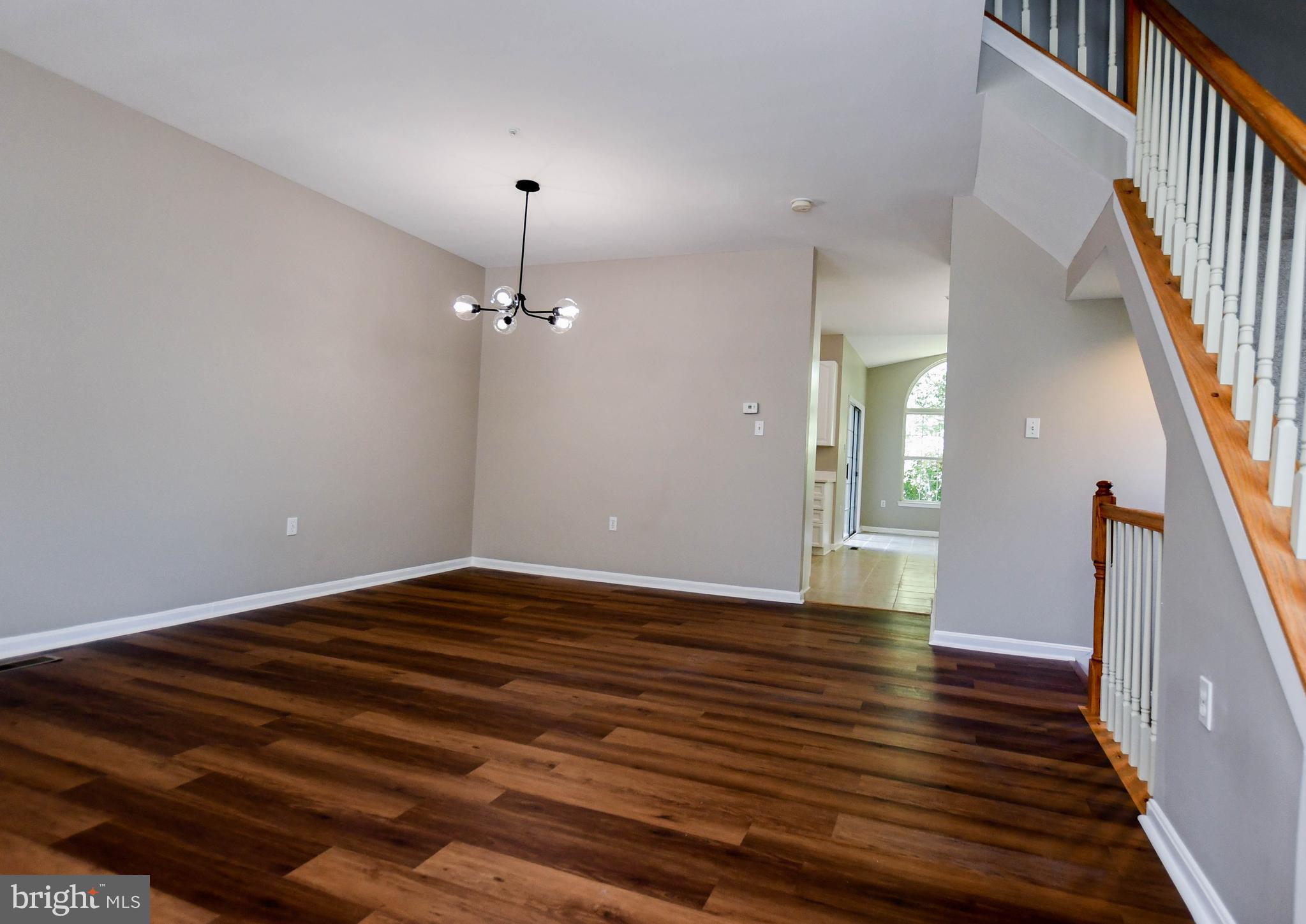 4308 Huntshire Road Randallstown, MD 21133 - Photo 12 of 40 a view of an empty room with wooden floor and stairs