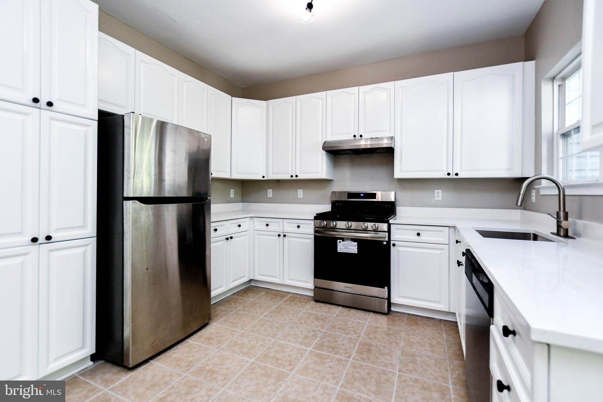 4308 Huntshire Road Randallstown, MD 21133 - Photo 3 of 40 a kitchen with stainless steel appliances a refrigerator stove and sink