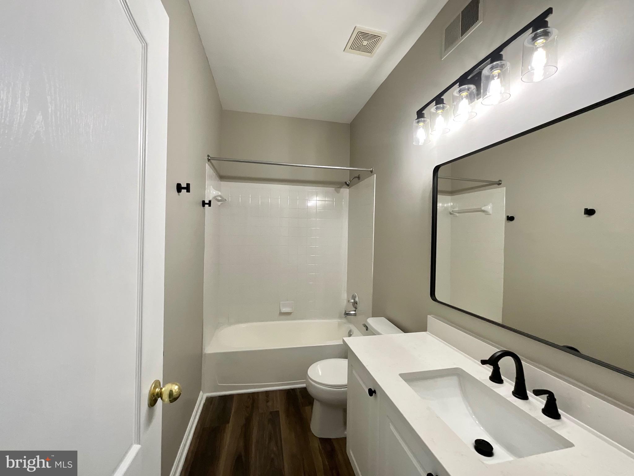 4308 Huntshire Road Randallstown, MD 21133 - Photo 34 of 40 a bathroom with a sink a toilet a mirror and shower