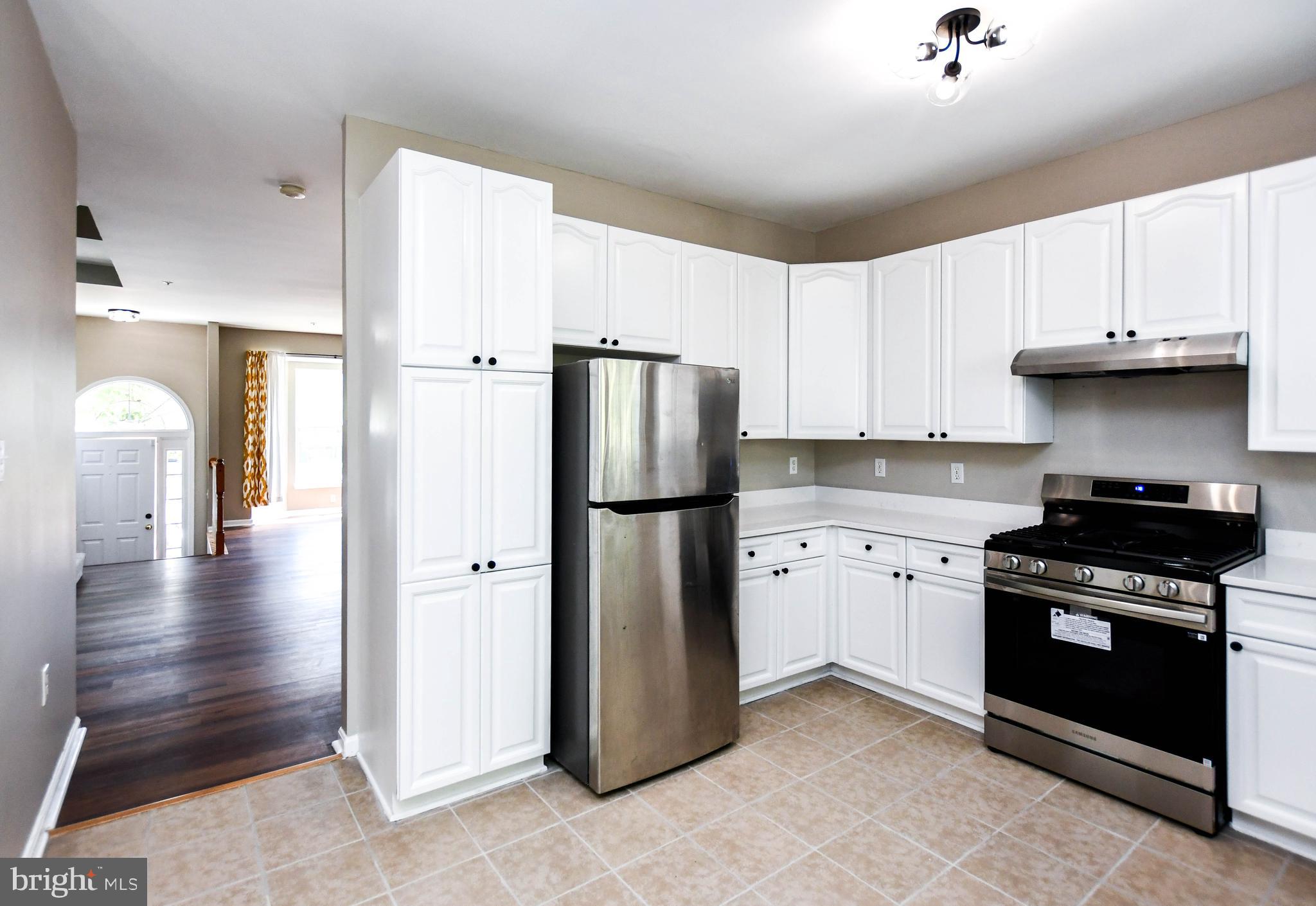 4308 Huntshire Road Randallstown, MD 21133 - Photo 4 of 40 a kitchen with stainless steel appliances granite countertop a refrigerator a stove and a sink