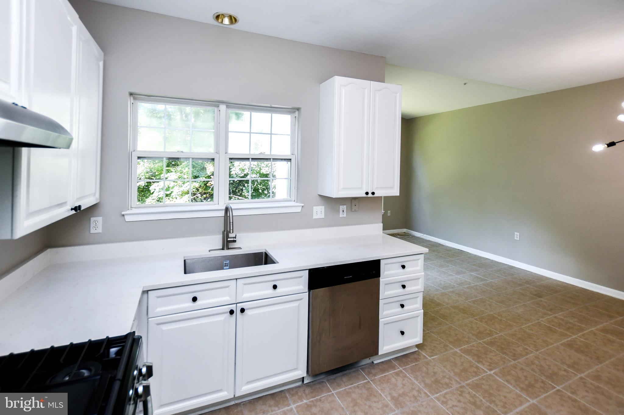 4308 Huntshire Road Randallstown, MD 21133 - Photo 5 of 40 a kitchen with white cabinets and a window