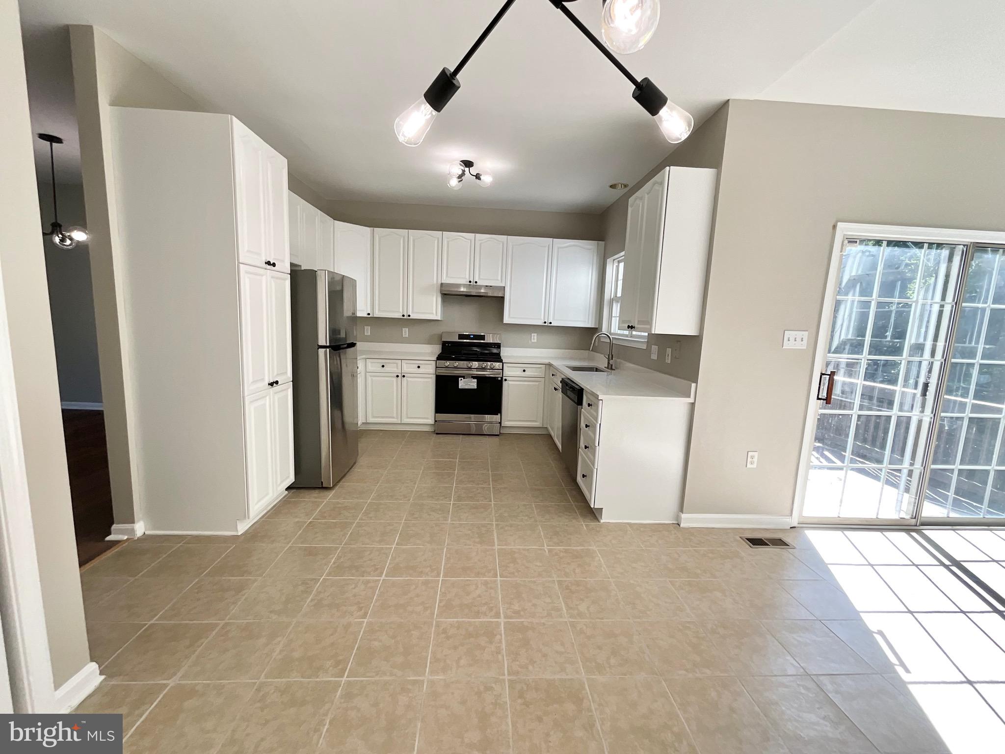 4308 Huntshire Road Randallstown, MD 21133 - Photo 6 of 40 a kitchen with stainless steel appliances granite countertop a refrigerator oven a sink a stove and a refrigerator