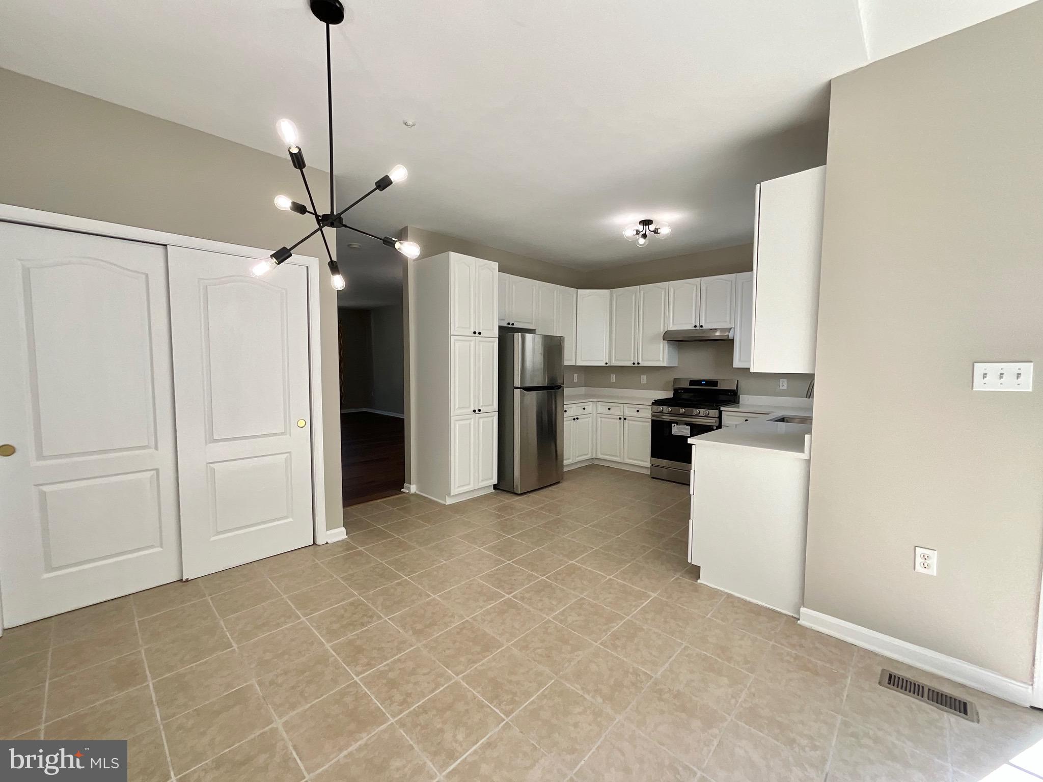 4308 Huntshire Road Randallstown, MD 21133 - Photo 7 of 40 a view of a kitchen with refrigerator and white cabinets