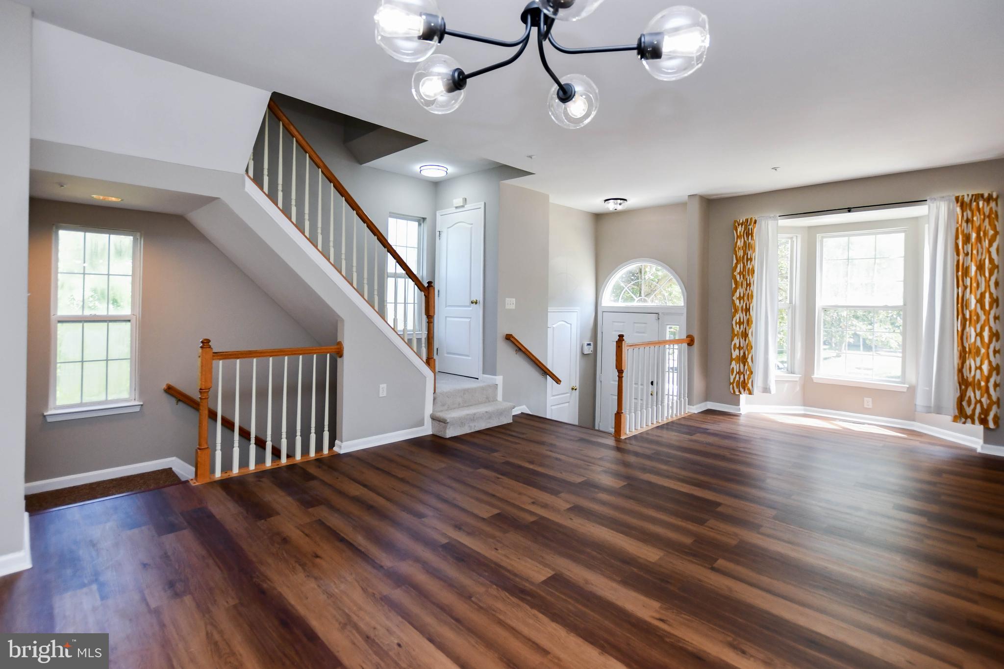 4308 Huntshire Road Randallstown, MD 21133 - Photo 8 of 40 a view of an empty room with wooden floor and fan