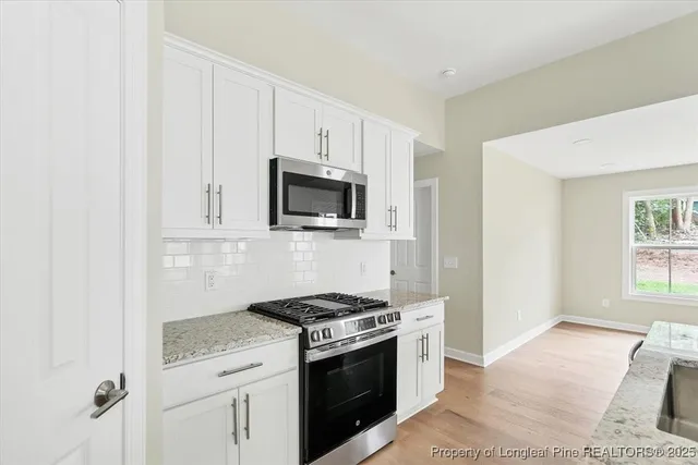 a kitchen with granite countertop white cabinets and appliances
