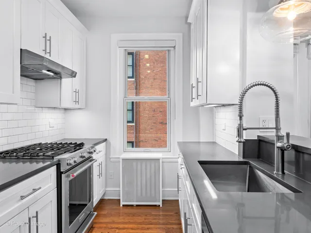 a kitchen with granite countertop a sink stainless steel appliances and cabinets