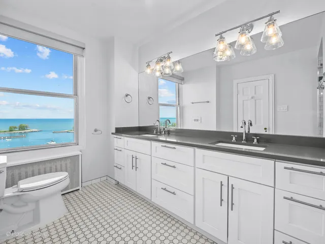 a bathroom with a granite countertop sink a toilet and a large mirror