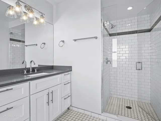 a bathroom with a granite countertop sink a shower and a mirror
