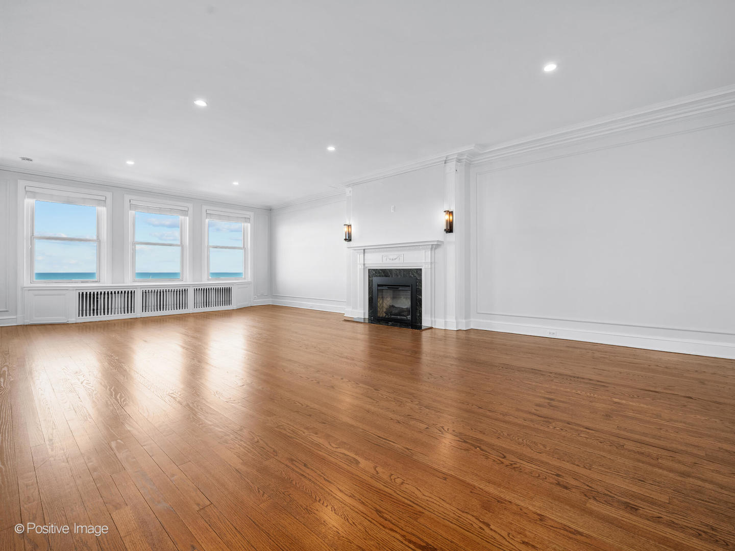 3240 North Lake Shore Drive, Unit 11B Chicago, IL 60657 - Photo 2 of 25 an empty room with wooden floor and a fireplace