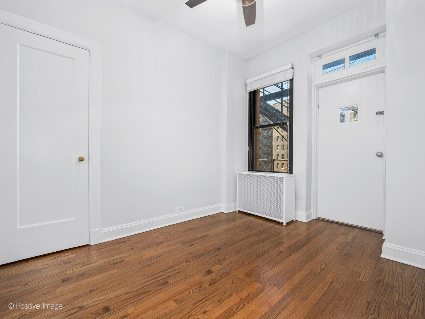 3240 North Lake Shore Drive, Unit 11B Chicago, IL 60657 - Photo 21 of 25 an empty room with wooden floor cabinet and windows