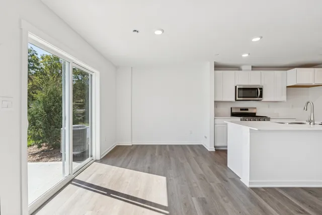 a kitchen with a hard wood floor window and a view of living room